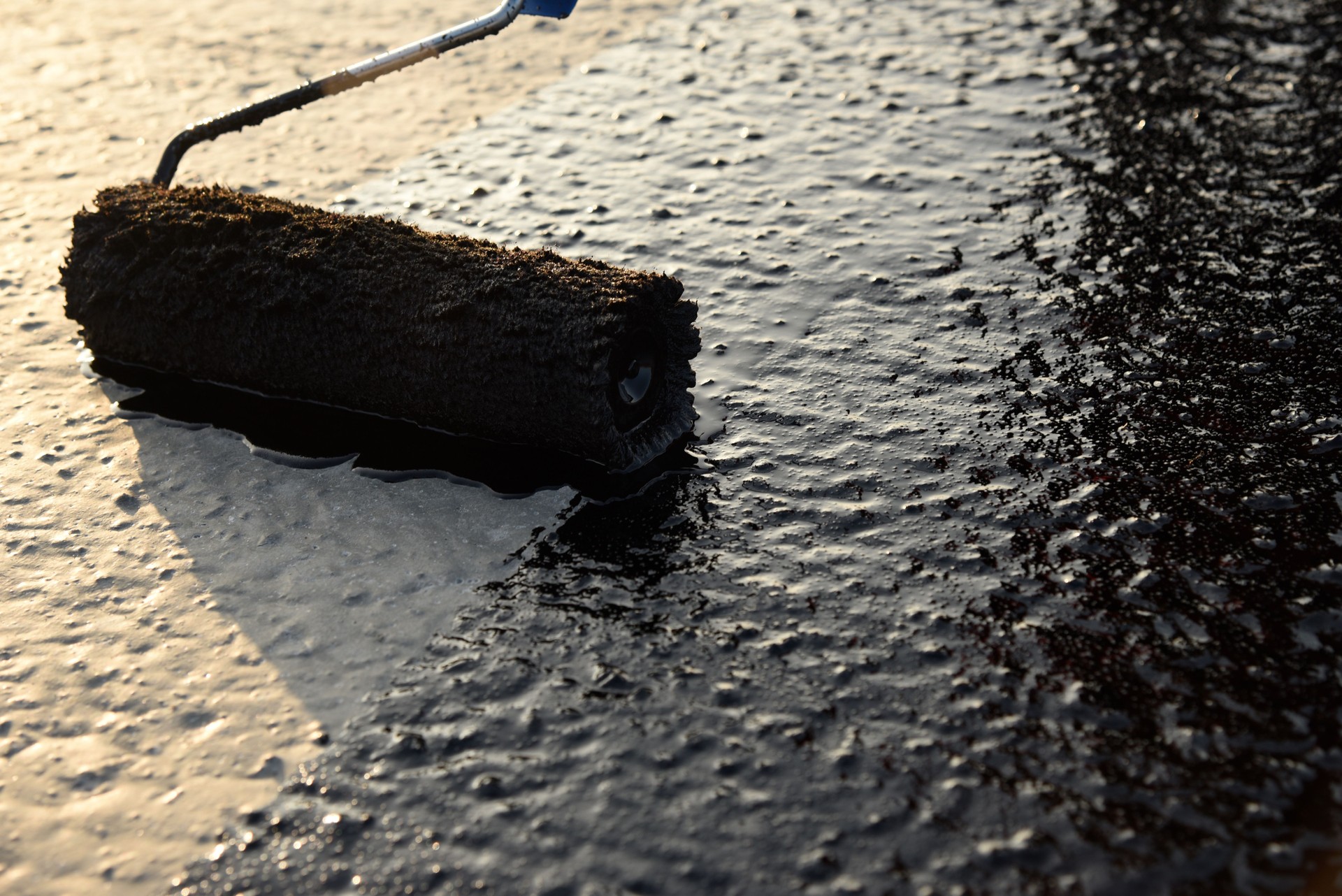 Worker applies bitumen mastic on the foundation